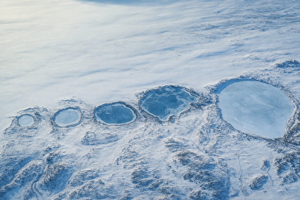 Aerial view of five separate frozen lakes of clearly different size lying in a row across a wide snow plain — the plate for compare in the licences section