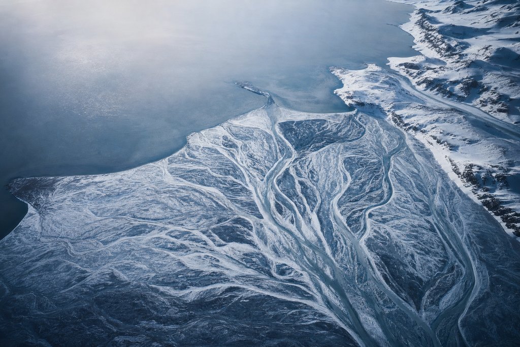 Aerial view of a branching frozen channel system in which each branch reaches a different outlet on a distant snow-covered coast — the plate for the complaint path builder