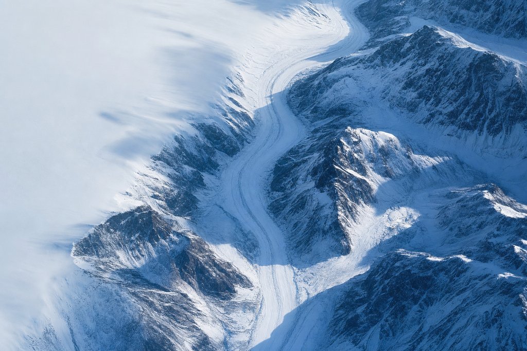 Aerial view of a single snow-covered valley seen from directly above, one clear route running through it between steep walls on either side — the plate for the province protection checker